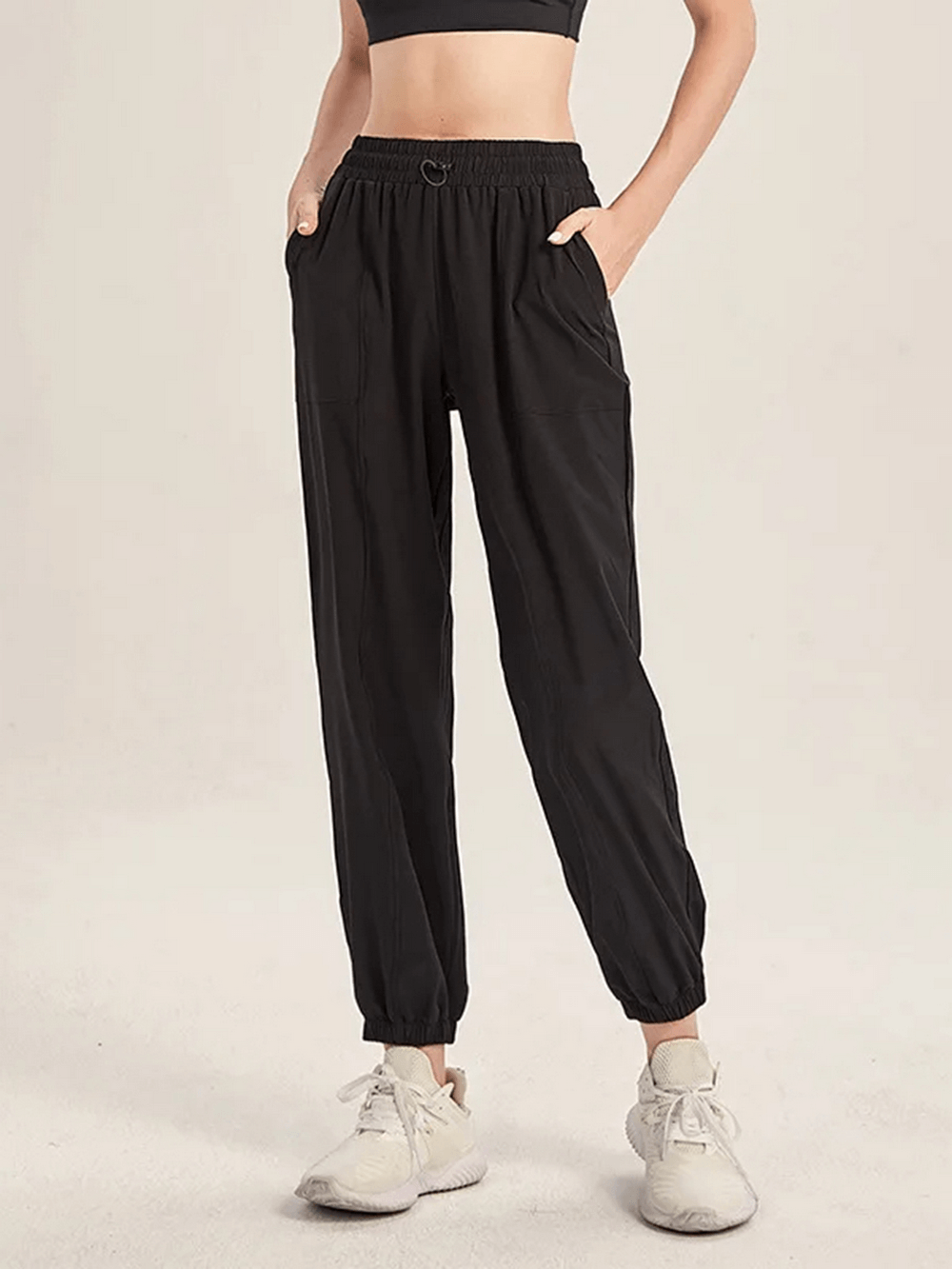 Stylish black drawstring joggers for yoga and gym, offering flexibility and snug fit for running and dance. Women's polyester pants.